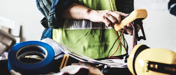 electrician using a multimeter on an electrical project